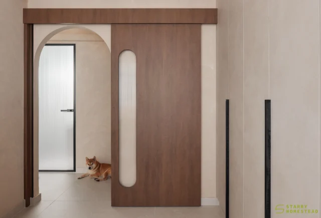 The walk-in wardrobe and bedroom are seamlessly connected by a Japanese-inspired sliding door and an arched doorway. 
The walk-in wardrobe carries a creamy, elegant tone, creating a calm and refined dressing experience with a light and understated mood. 
In contrast, the bedroom adopts a deeper, more grounded vibe, with dark wood elements and beige limewash walls that add warmth and quiet depth. 
Together, the two spaces create a gentle transition between light elegance and richer, moodier textures, unified by a sense of balance and calm.
-
Canberra Vista // Wabi-Sabi
Designer: Si Han
-
#singapore #renovation #interiordesign #qanvast #homematch #hometrust #homedecor #interiors #interiorinspo #interiordesigninspo #renovationinspo #sginteriordesign #sgrenovation #interior #design #singaporehomes #sghome #hdb #bto #condo #modern #comtemporary #wabisabi #japandi #bedroom #walkinwardrobe
